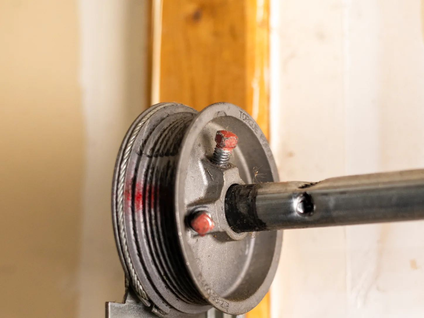 Garage door cable drum and end bearing plate at the top of the vertical track