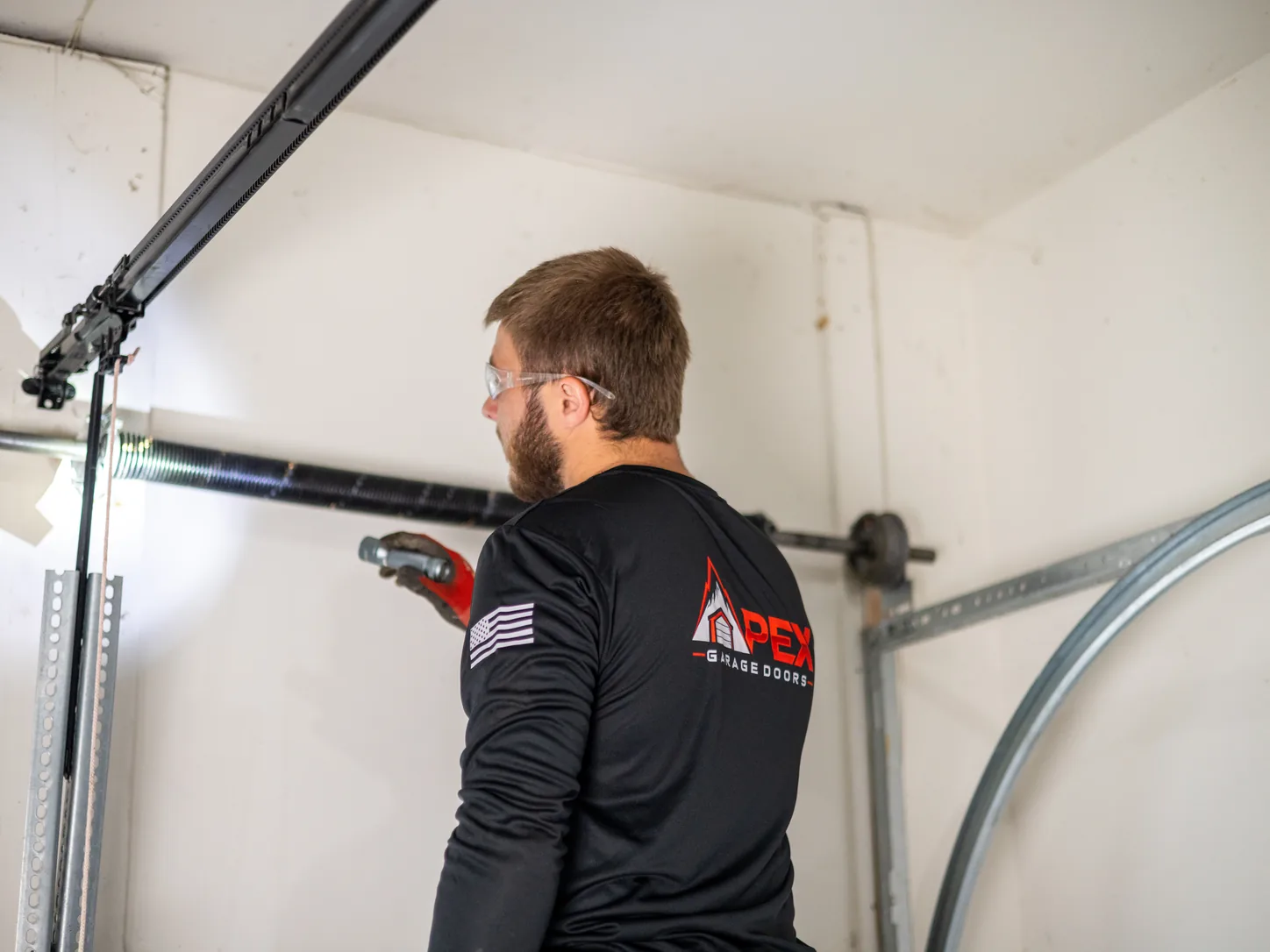 Apex Garage Doors technician checking the opener rail and track of a residential garage door