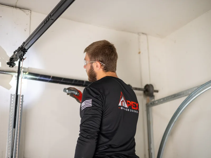 Apex Garage Doors technician inspecting the horizontal track and opener rail inside a garage
